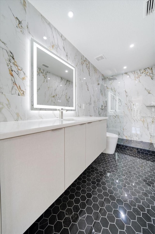 bathroom featuring tile walls, tile floors, toilet, and vanity