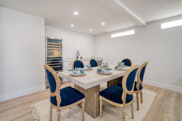 dining area featuring light hardwood / wood-style floors, a textured ceiling, and sink