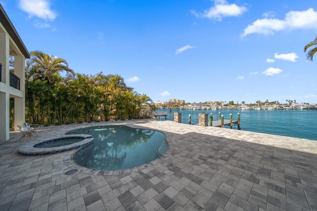 view of swimming pool with an in ground hot tub, a water view, and a patio