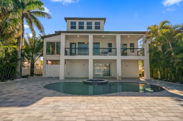 rear view of property featuring a balcony and a patio area