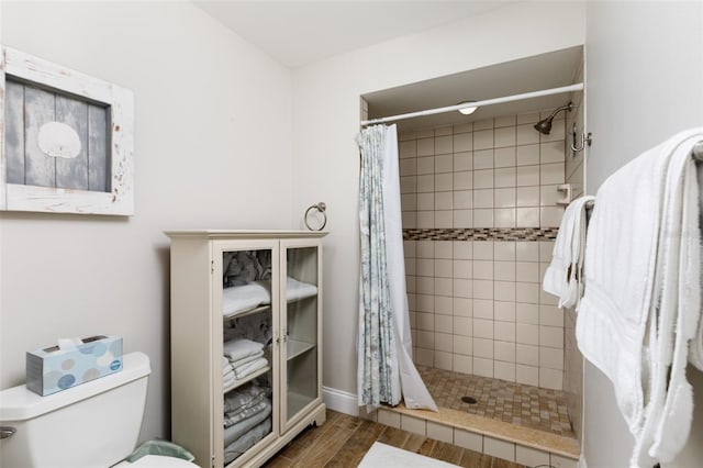 bathroom featuring walk in shower and toilet