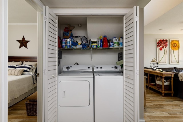 clothes washing area featuring independent washer and dryer and light hardwood / wood-style flooring