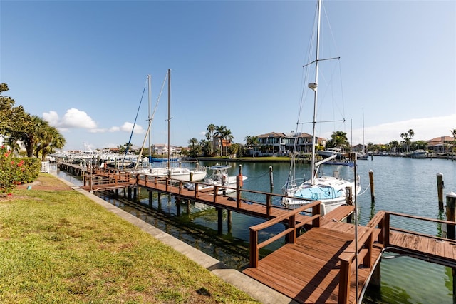 view of dock featuring a water view and a yard