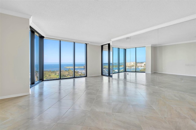 tiled empty room featuring crown molding, a water view, expansive windows, and a wealth of natural light