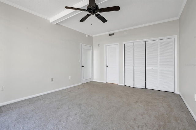 unfurnished bedroom featuring ornamental molding, carpet flooring, ceiling fan, and beamed ceiling