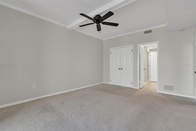 carpeted spare room with ceiling fan and beam ceiling