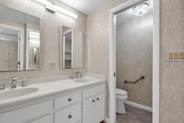 bathroom with toilet, dual sinks, tile floors, and oversized vanity