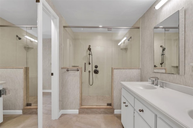 bathroom with tile floors, a shower with shower door, and vanity