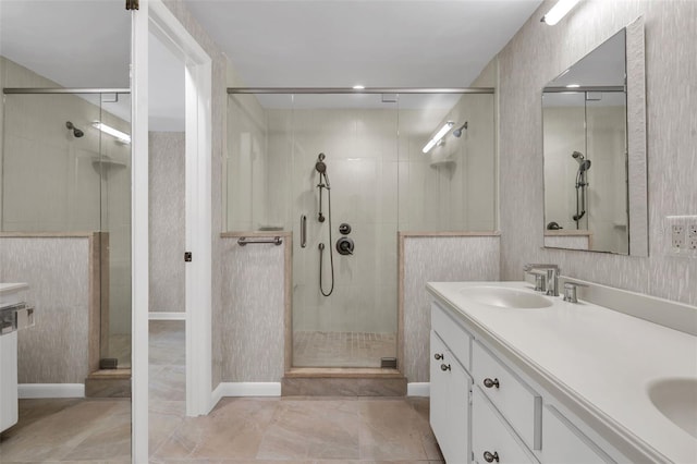 bathroom with tile flooring, dual vanity, and a shower with shower door