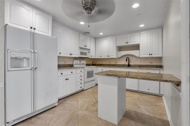 kitchen featuring white cabinets, ceiling fan, and white appliances