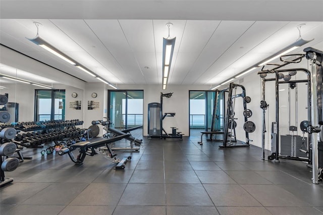 workout area with plenty of natural light and dark tile floors