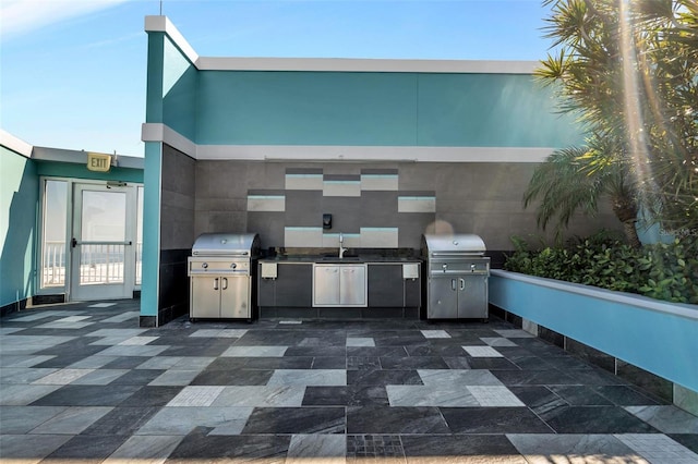 view of patio / terrace featuring exterior kitchen, area for grilling, and sink