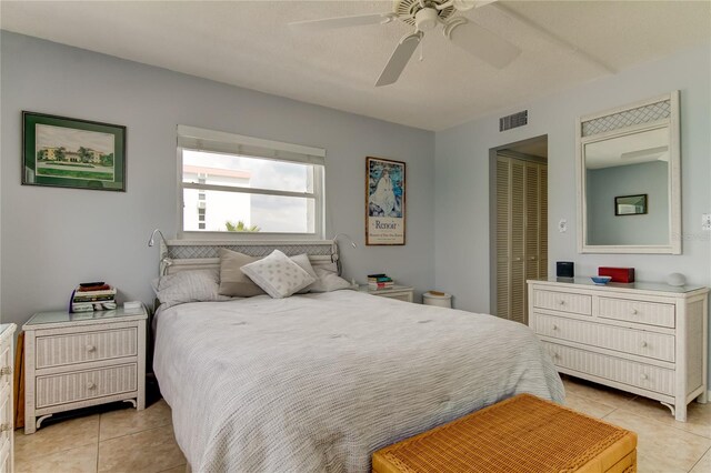 bedroom with light tile patterned flooring, ceiling fan, and a closet