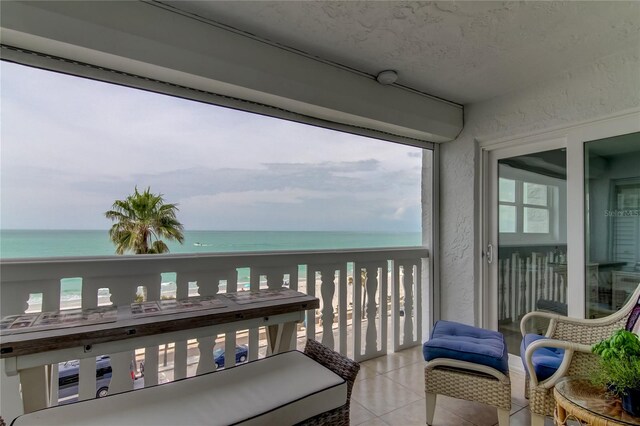 balcony with a water view and a beach view