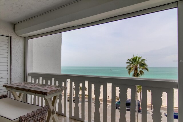 balcony featuring a beach view and a water view