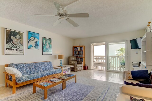 tiled living room featuring ceiling fan and a textured ceiling