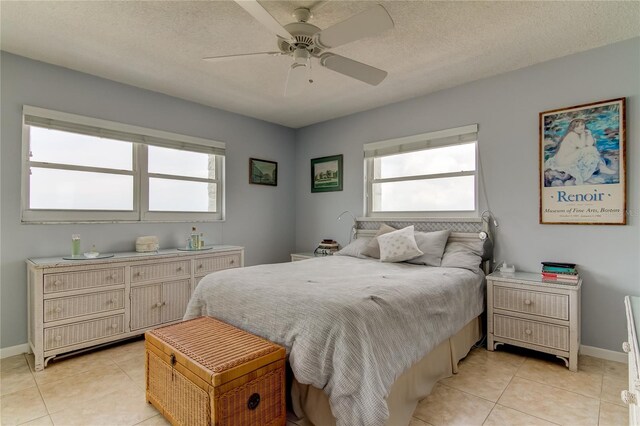 tiled bedroom with ceiling fan and a textured ceiling