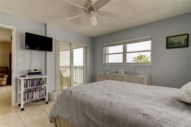 bedroom featuring ceiling fan, a textured ceiling, and light tile patterned floors