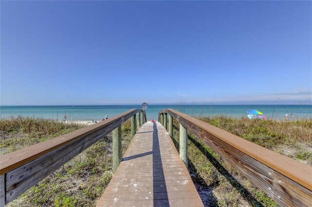 view of home's community featuring a water view and a beach view