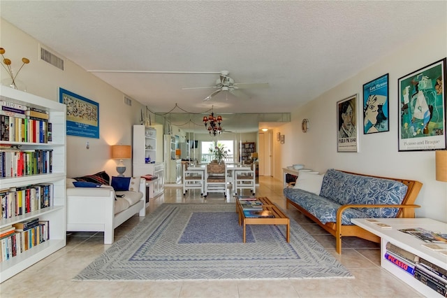 living room featuring ceiling fan, tile patterned floors, and a textured ceiling