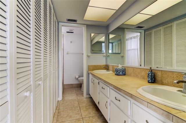 bathroom with vanity, toilet, and tile patterned flooring