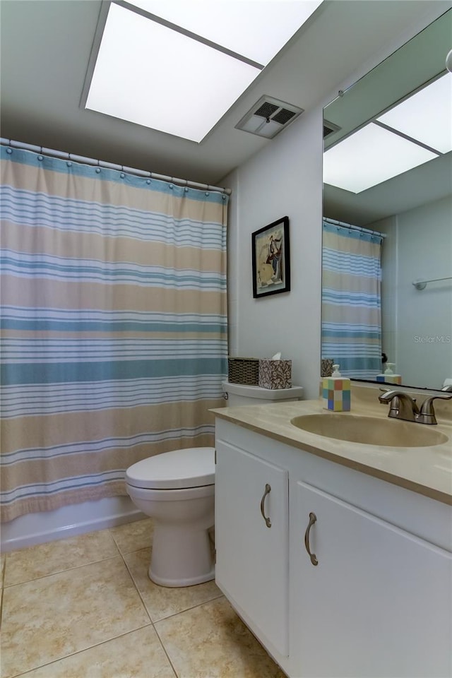 full bathroom featuring shower / tub combo with curtain, toilet, a skylight, vanity, and tile patterned flooring