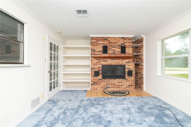 unfurnished living room featuring light carpet, brick wall, built in shelves, and a fireplace