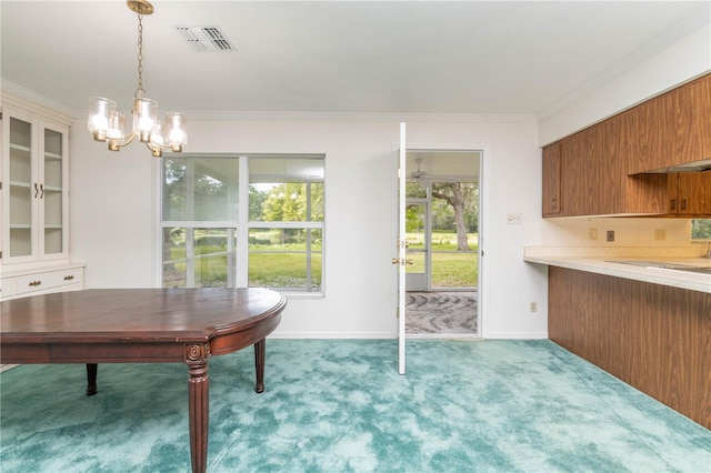 unfurnished dining area with an inviting chandelier, ornamental molding, and light colored carpet