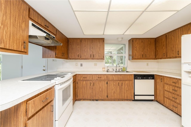 kitchen featuring white appliances, sink, and light tile floors