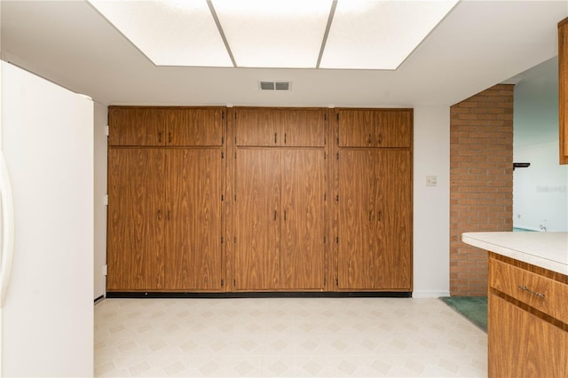 interior space featuring brick wall and light tile flooring