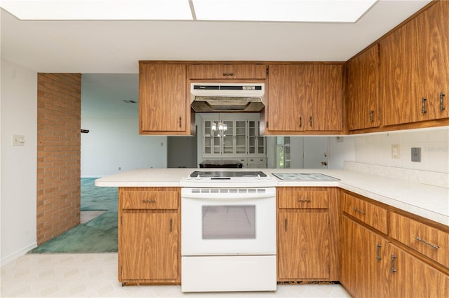 kitchen featuring brick wall, light colored carpet, white range oven, a chandelier, and tasteful backsplash