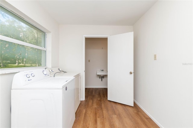 washroom with sink, light wood-type flooring, and washer and clothes dryer