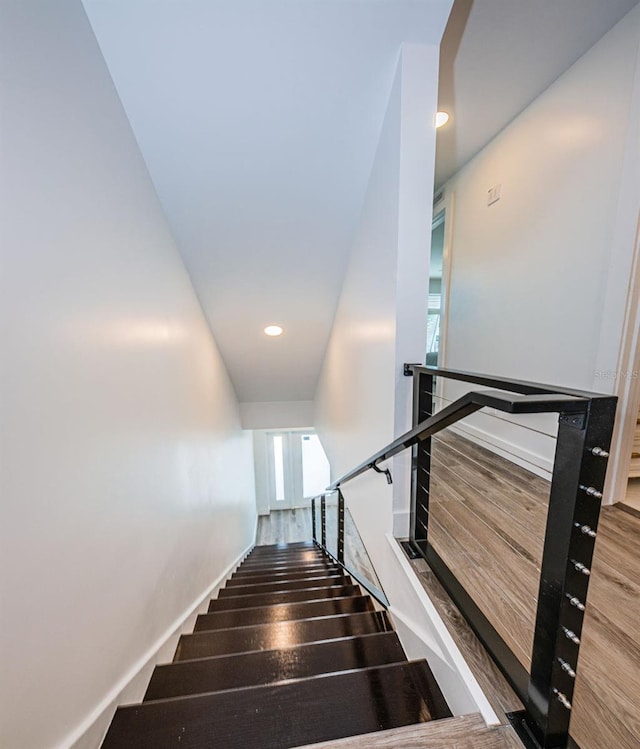 stairway with dark hardwood / wood-style flooring and a towering ceiling