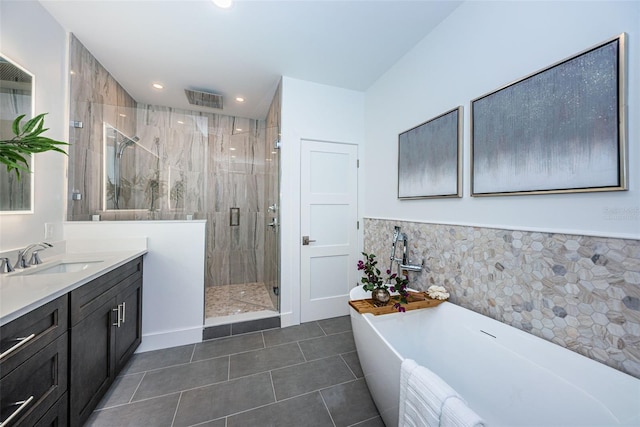 bathroom featuring plus walk in shower, vanity, and tile flooring