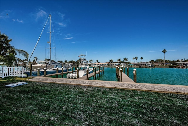 dock area with a lawn and a water view