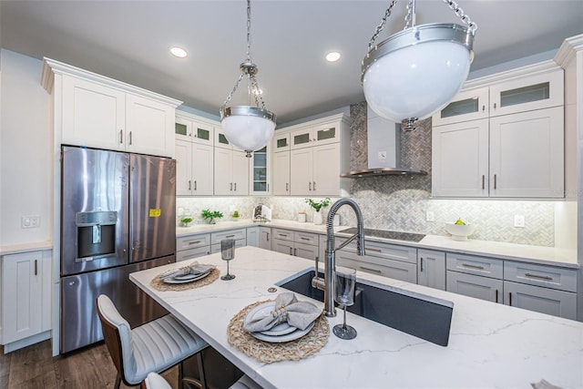 kitchen featuring backsplash, light stone countertops, stainless steel fridge with ice dispenser, and white cabinetry