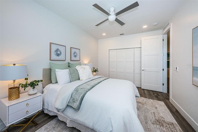 bedroom with dark hardwood / wood-style flooring, ceiling fan, and a closet