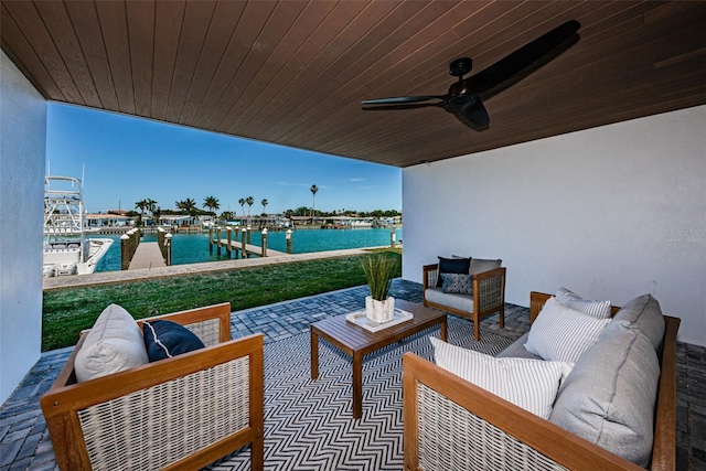 view of patio / terrace with a water view, ceiling fan, an outdoor hangout area, and a boat dock