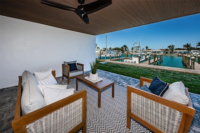 view of patio featuring a water view, ceiling fan, an outdoor hangout area, and a boat dock