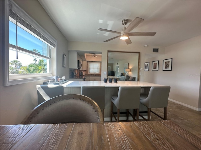 kitchen with hardwood / wood-style floors, kitchen peninsula, and a breakfast bar