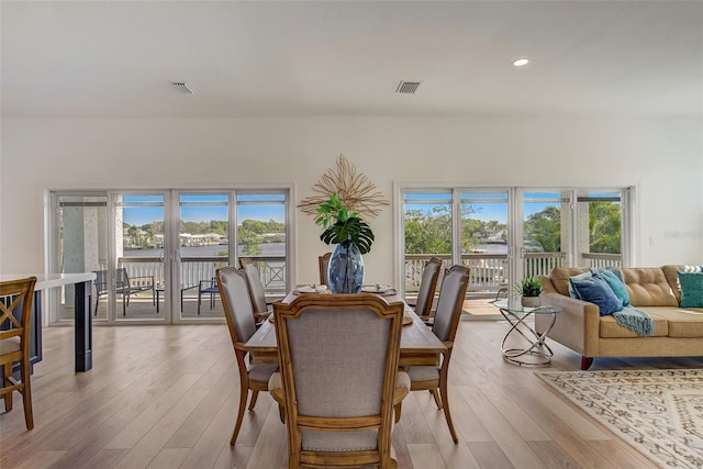 dining room with a healthy amount of sunlight and light hardwood / wood-style flooring