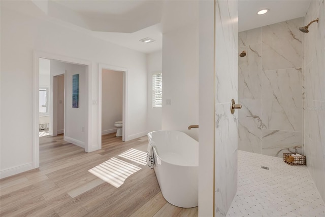 bathroom with wood-type flooring, shower with separate bathtub, and toilet