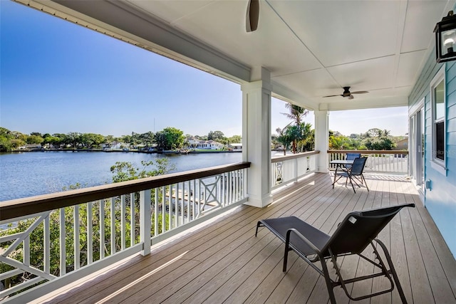 deck with ceiling fan and a water view