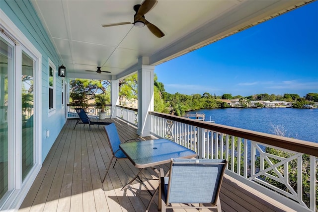 wooden deck with ceiling fan and a water view