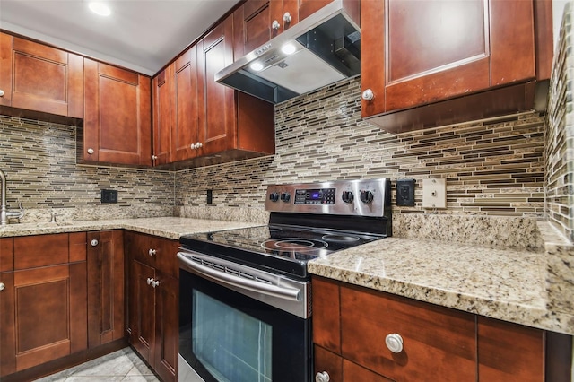 kitchen with stainless steel electric range oven, tasteful backsplash, light stone countertops, exhaust hood, and light tile patterned flooring