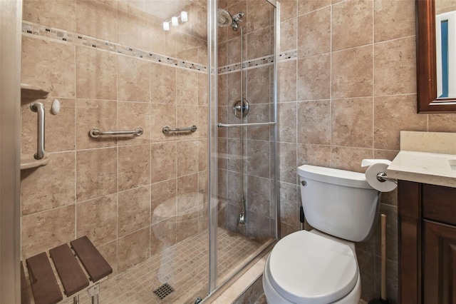 bathroom with vanity, toilet, tile walls, and an enclosed shower