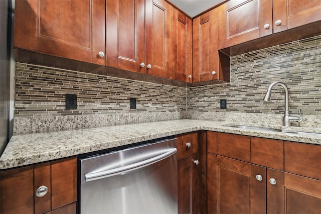 kitchen featuring sink, dishwasher, light stone counters, and decorative backsplash