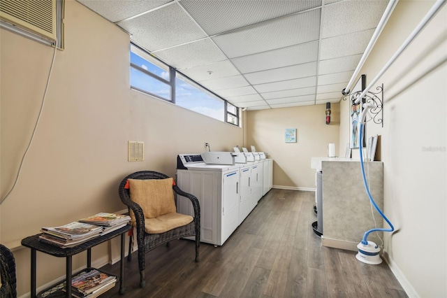 laundry room featuring washer and dryer, wood-type flooring, and an AC wall unit