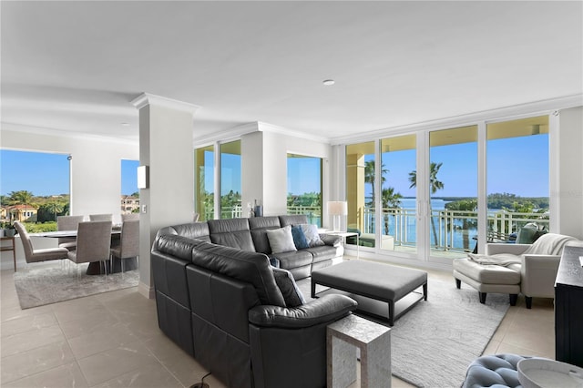 tiled living room featuring plenty of natural light, crown molding, and a water view