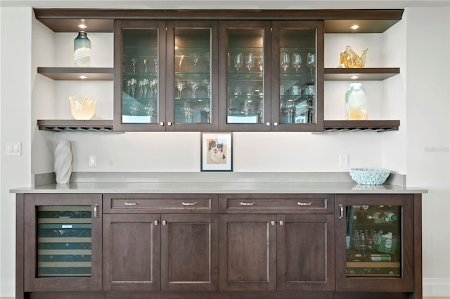 bar with wine cooler and dark brown cabinetry